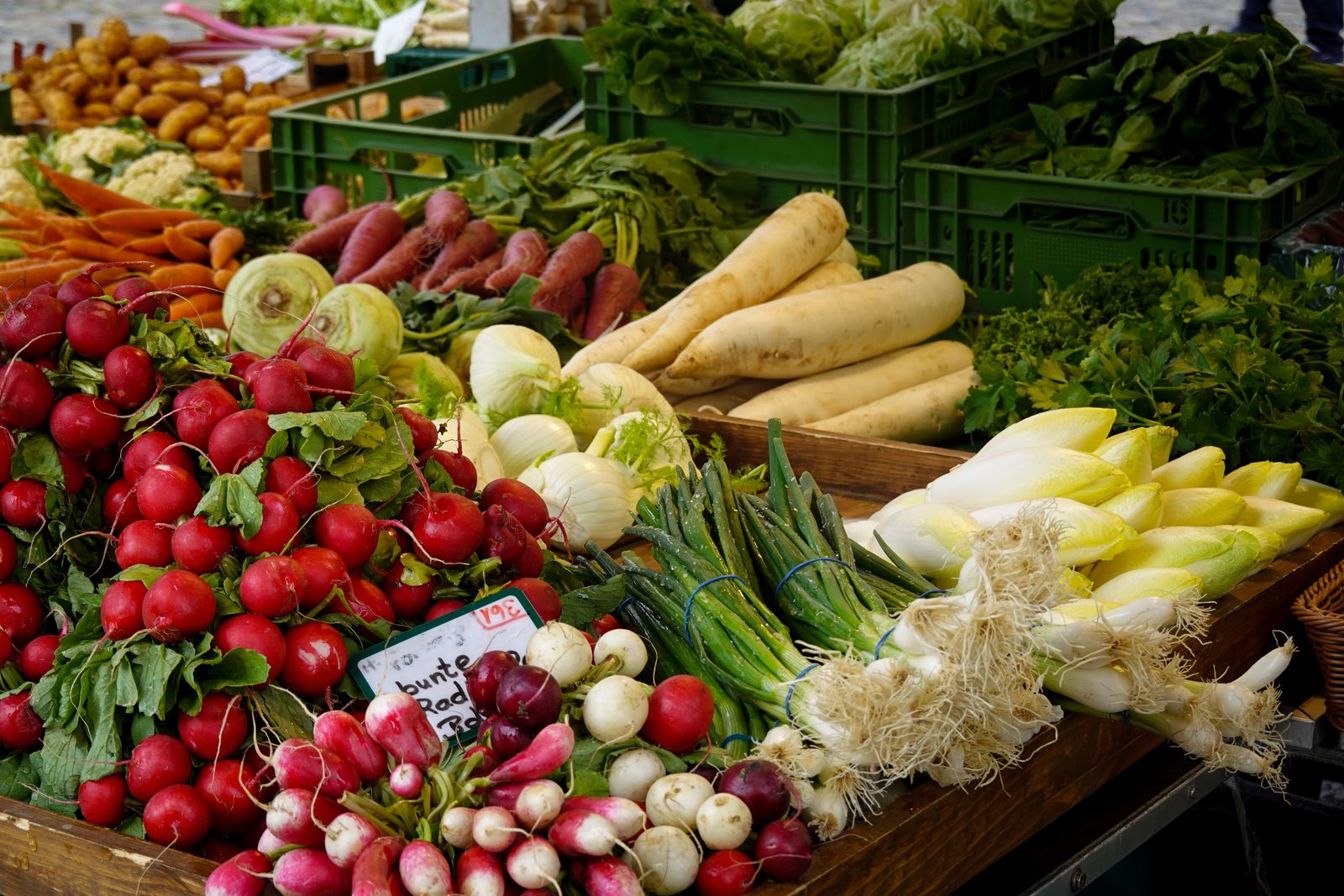 Les barquettes de figues fraîches et les fruits d'un étal du marché, sous l'arche de pierre, l'ardoise annonçant le prix en euros