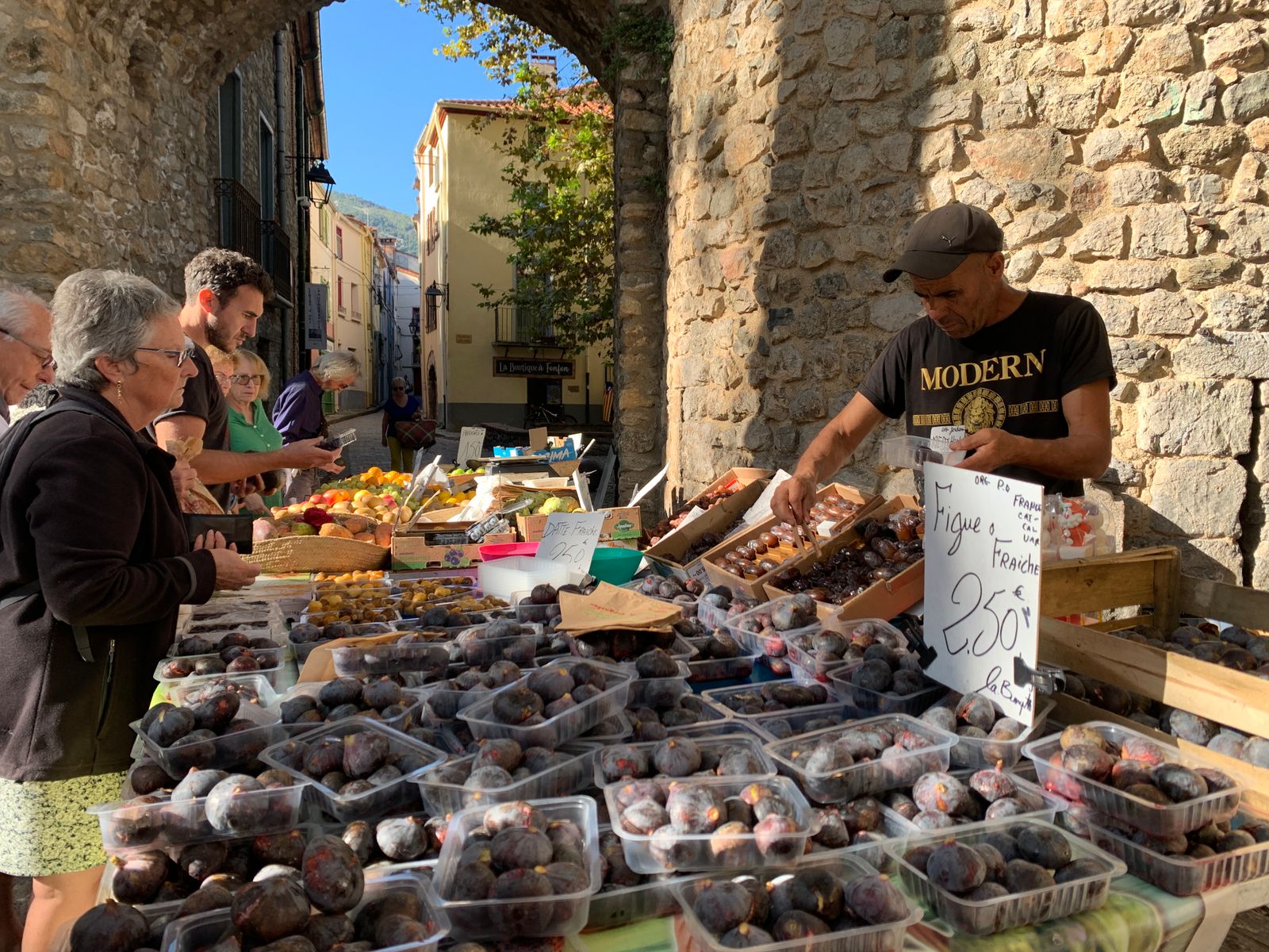 Les piliers de pierre de la halle aux grains, un étal dressé sous la charpente