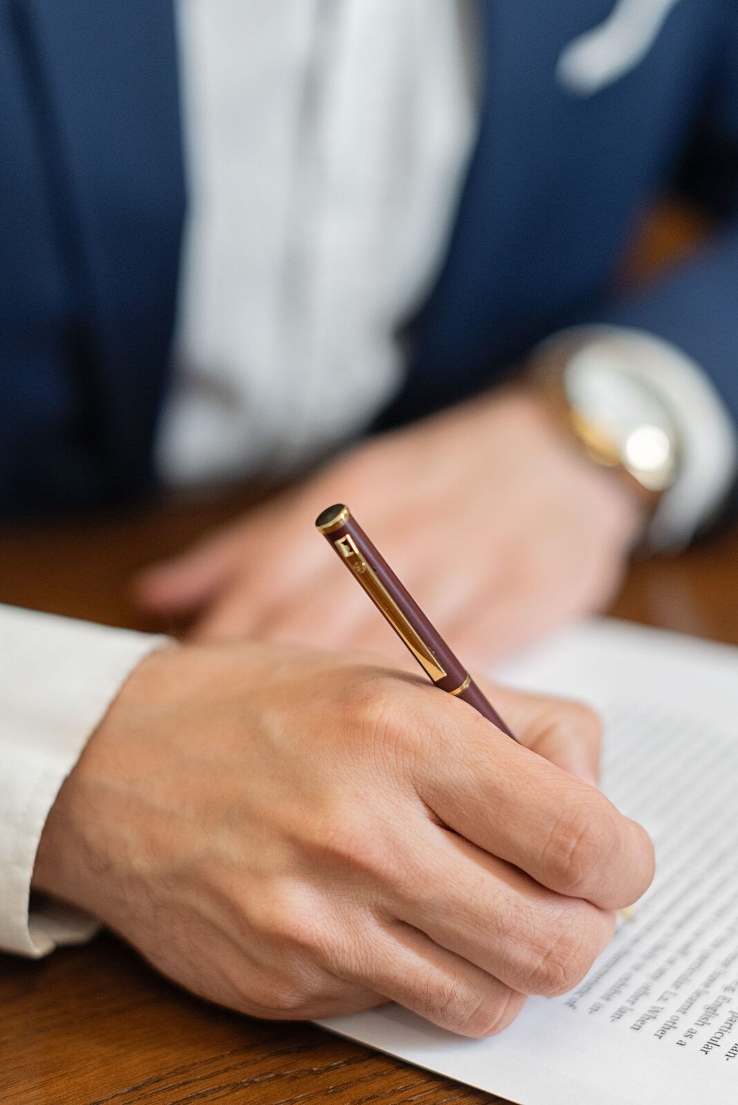 Une main signe au stylo le registre des délibérations