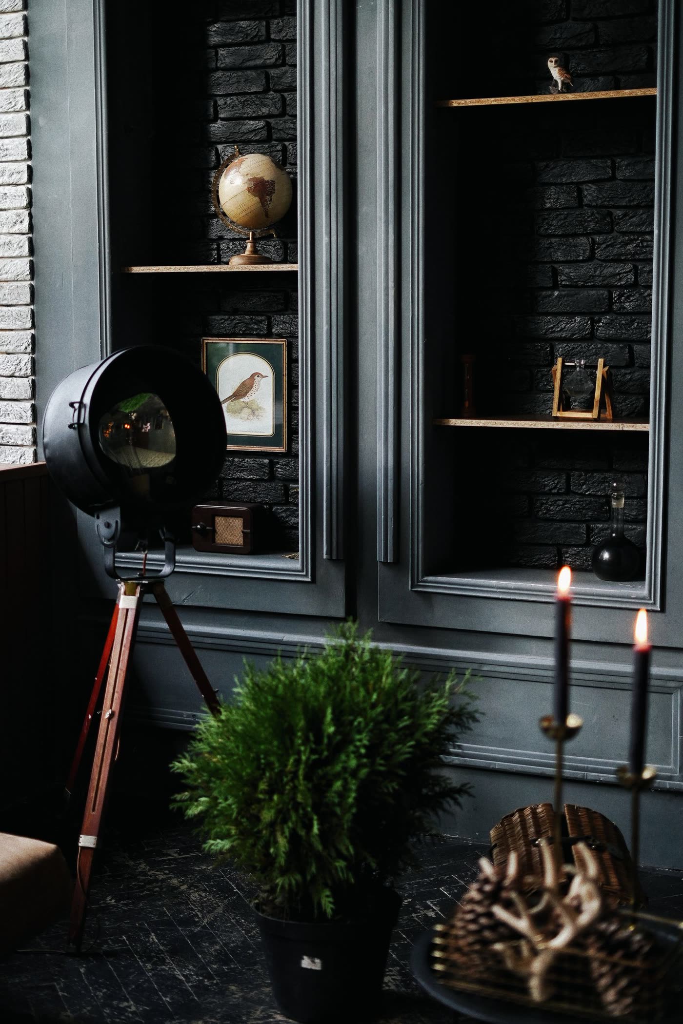 Coin de l'atelier, boiseries sombres, objets et bougies